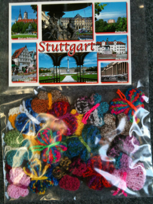Plastikbeutel mit einer Ansichtskarte aus Stuttgart und 22 Häkel-Schmetterlingen.