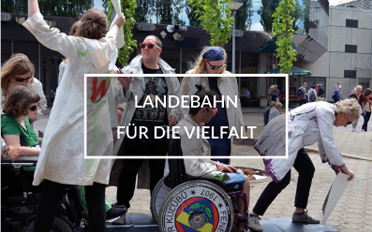 Schauspieler auf dem Kirchentag in Berlin. In der Mitte steht: "Landebahn für die Vielfalt"