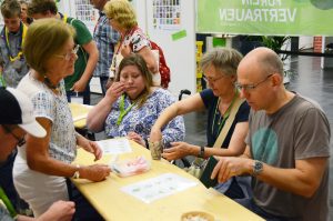 Kirchentags-Besucher falten Wachstuch-Becher.