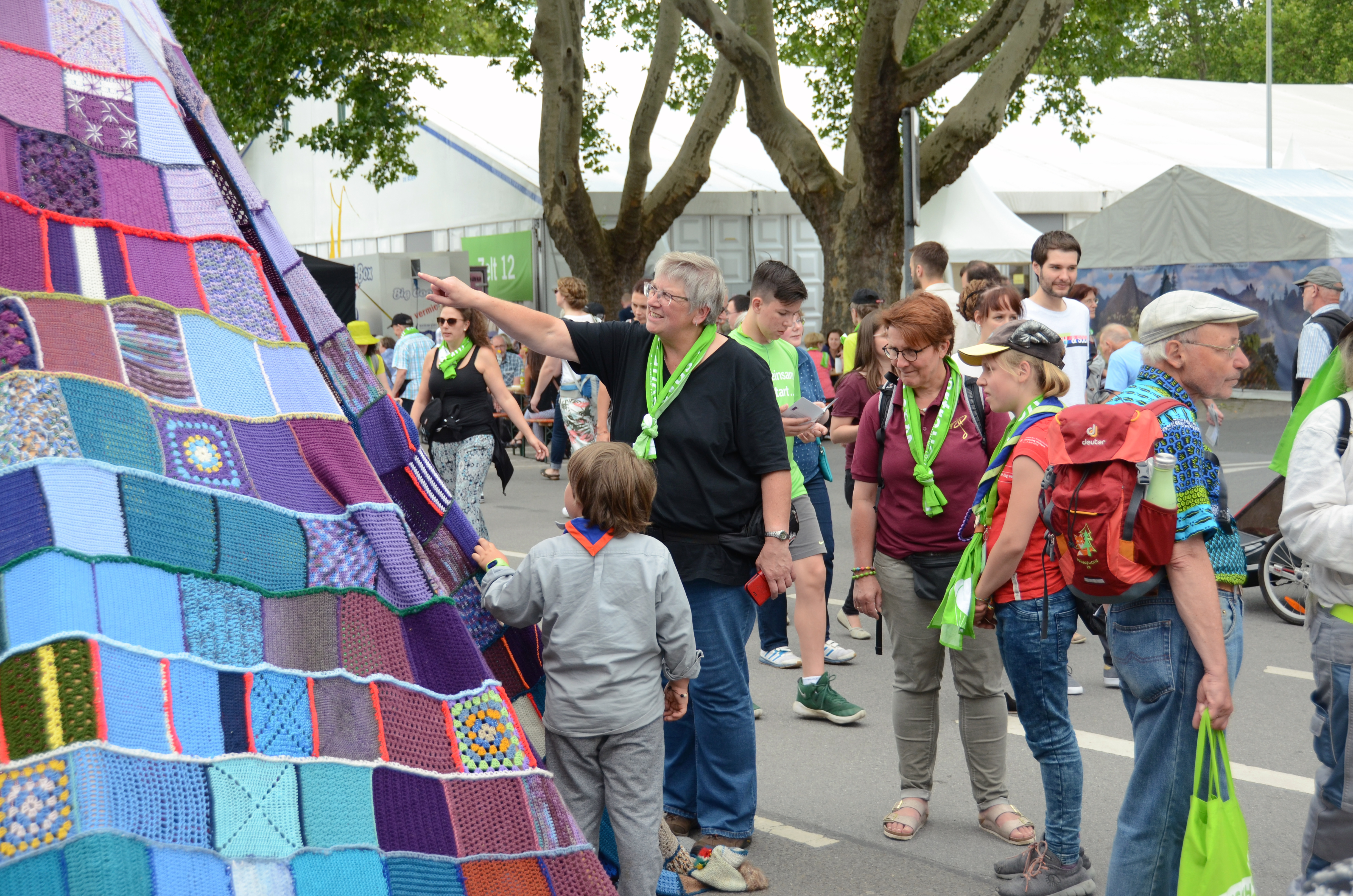 Eine Kirchentags-Besucherin zeig auf ein Detail am Tipi.